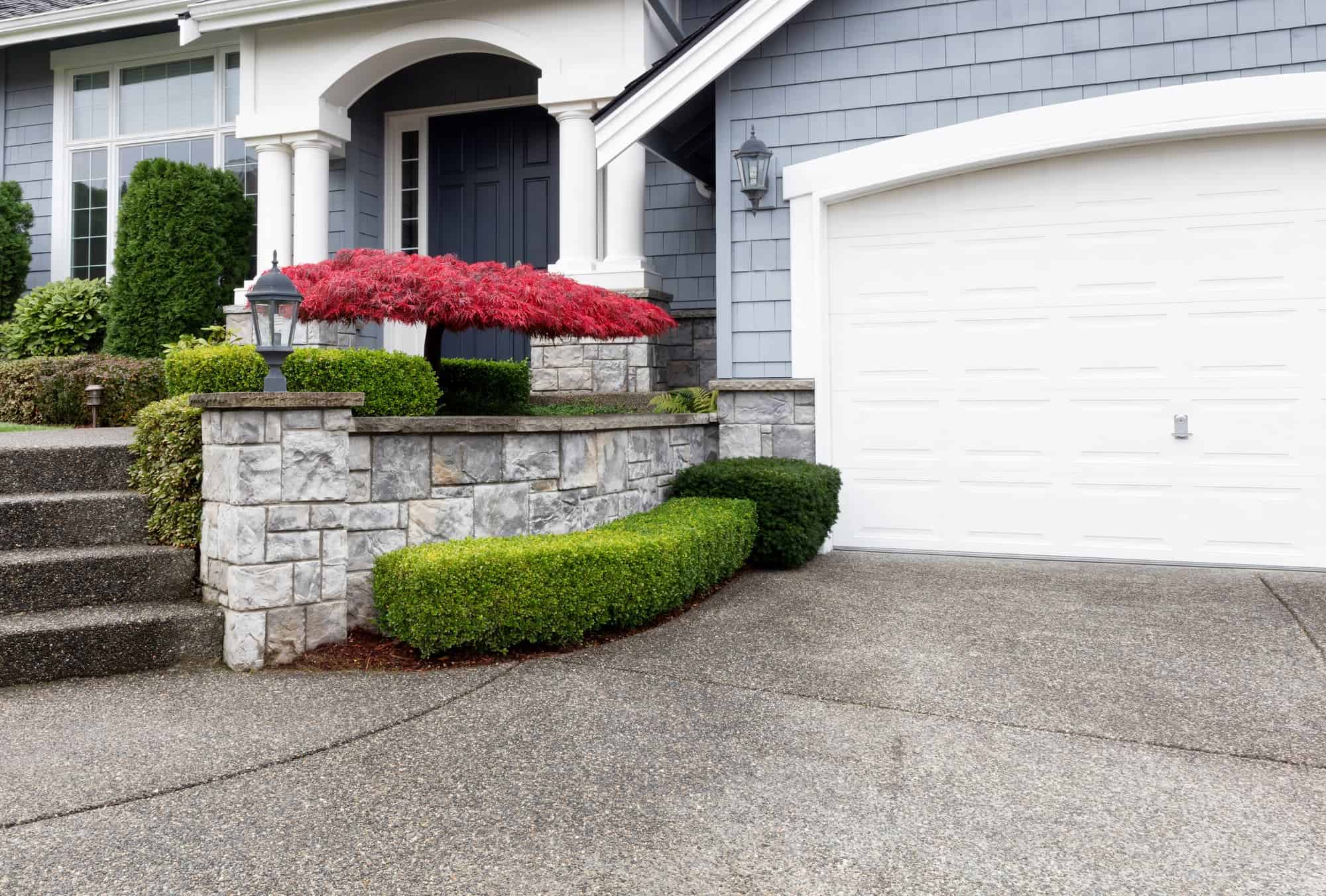 A beautiful residential home with an expertly crafted sidewalk and concrete driveway.