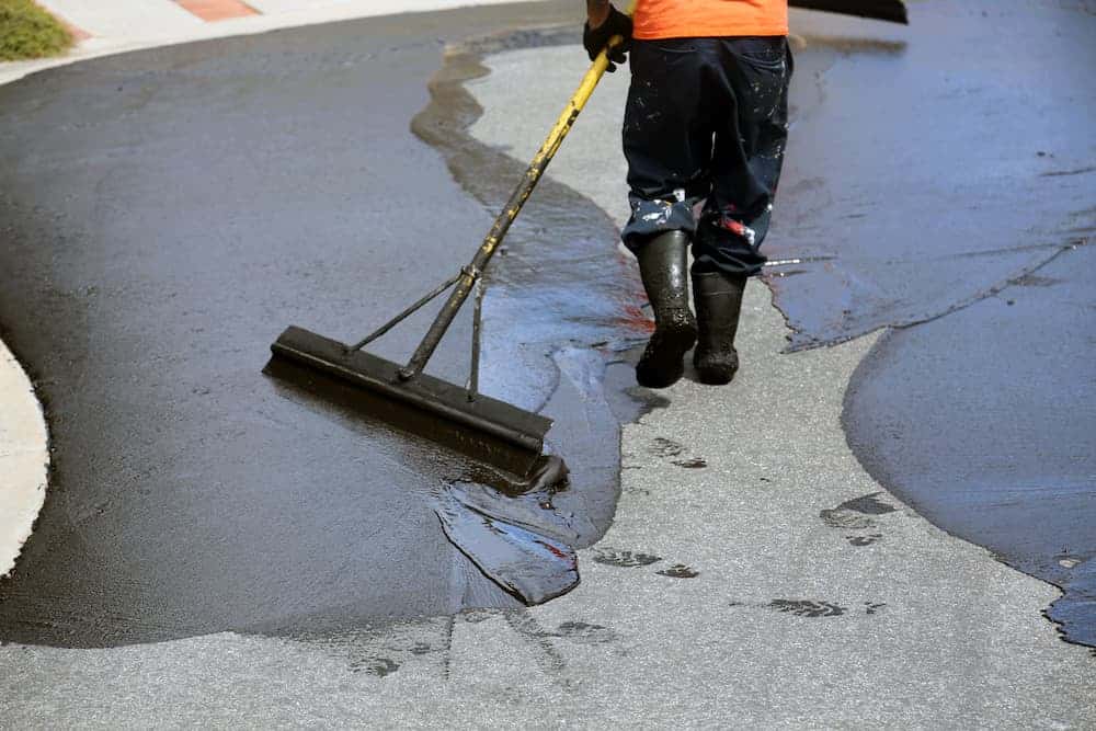 A seal coat being applied to a residential driveway